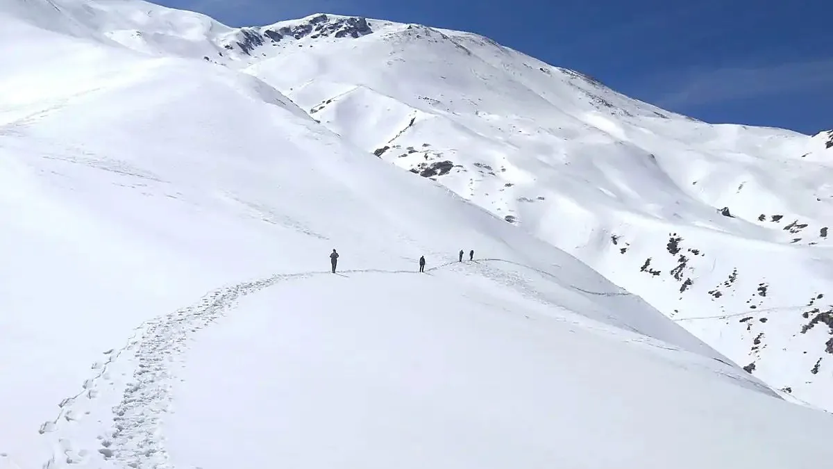 Trekkers crossing deep snow on the Brahmatal trek, where winter temperatures stay near or below freezing