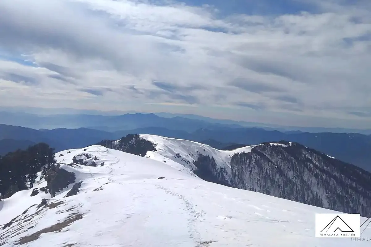 Clouds building over a snowy ridge on the Brahmatal trek as the weather changes