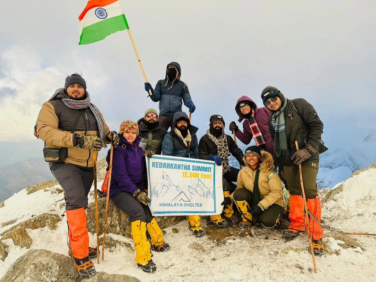 Trekkers in winter layers at the Kedarkantha summit