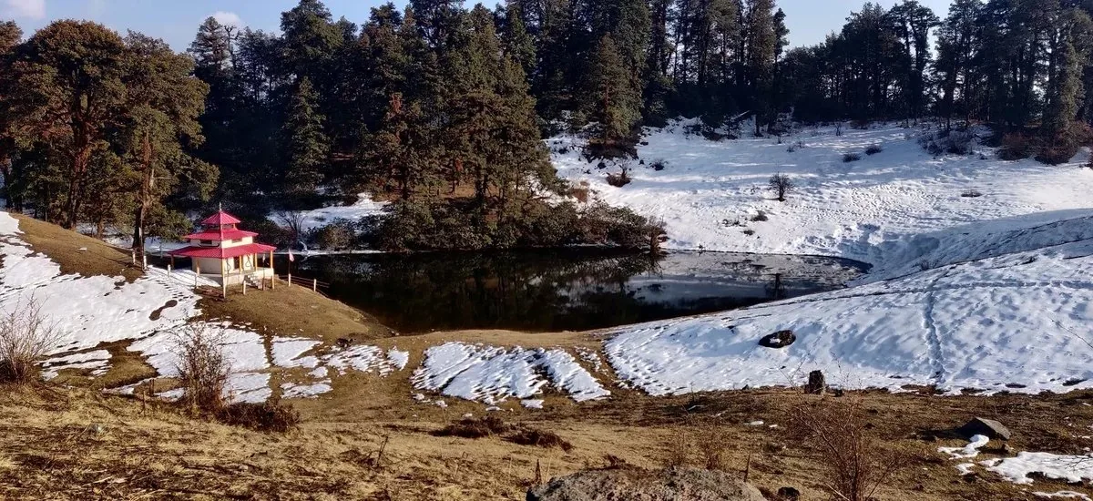 Melting snow patches around Barnala lake and its red-roofed temple on the route to Dayara Bugyal, as the March temperature rises