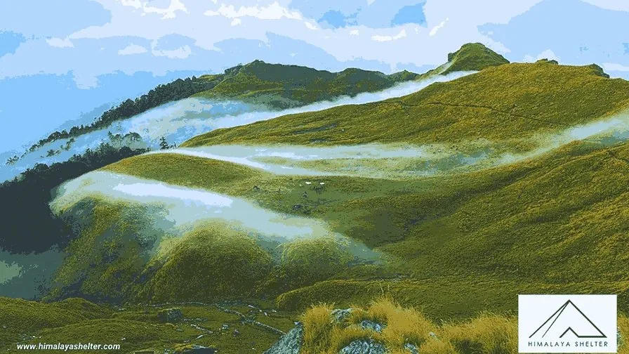 Green meadows and ridges on the Rudranath trek with low clouds drifting through the valley below